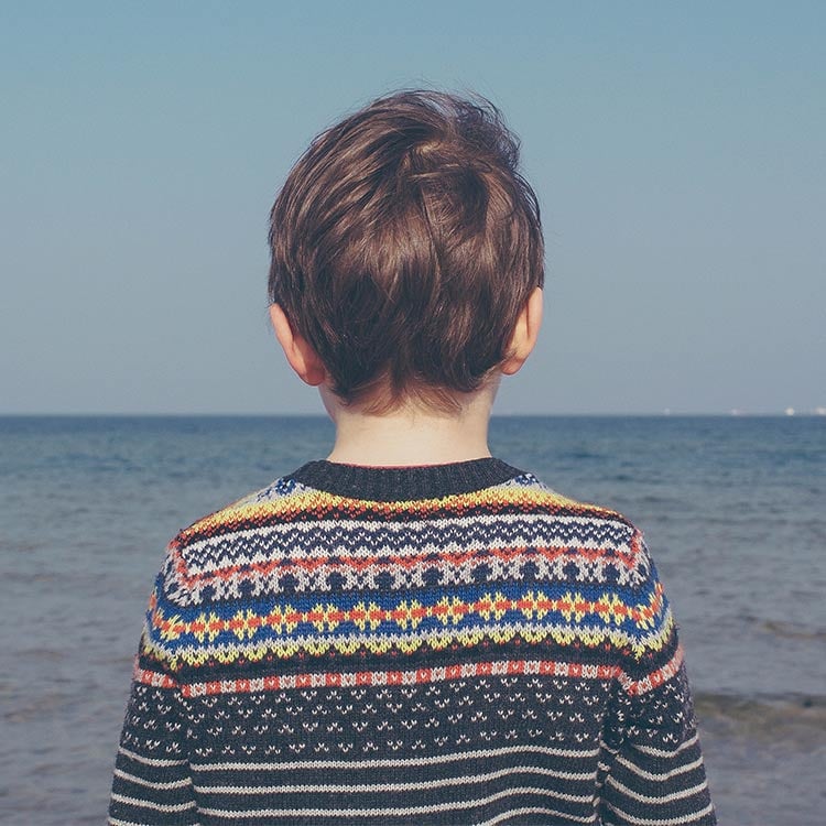 Boy_wearing_jumper_looking_out_to_sea