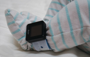 A baby wearing an Actiwatch device